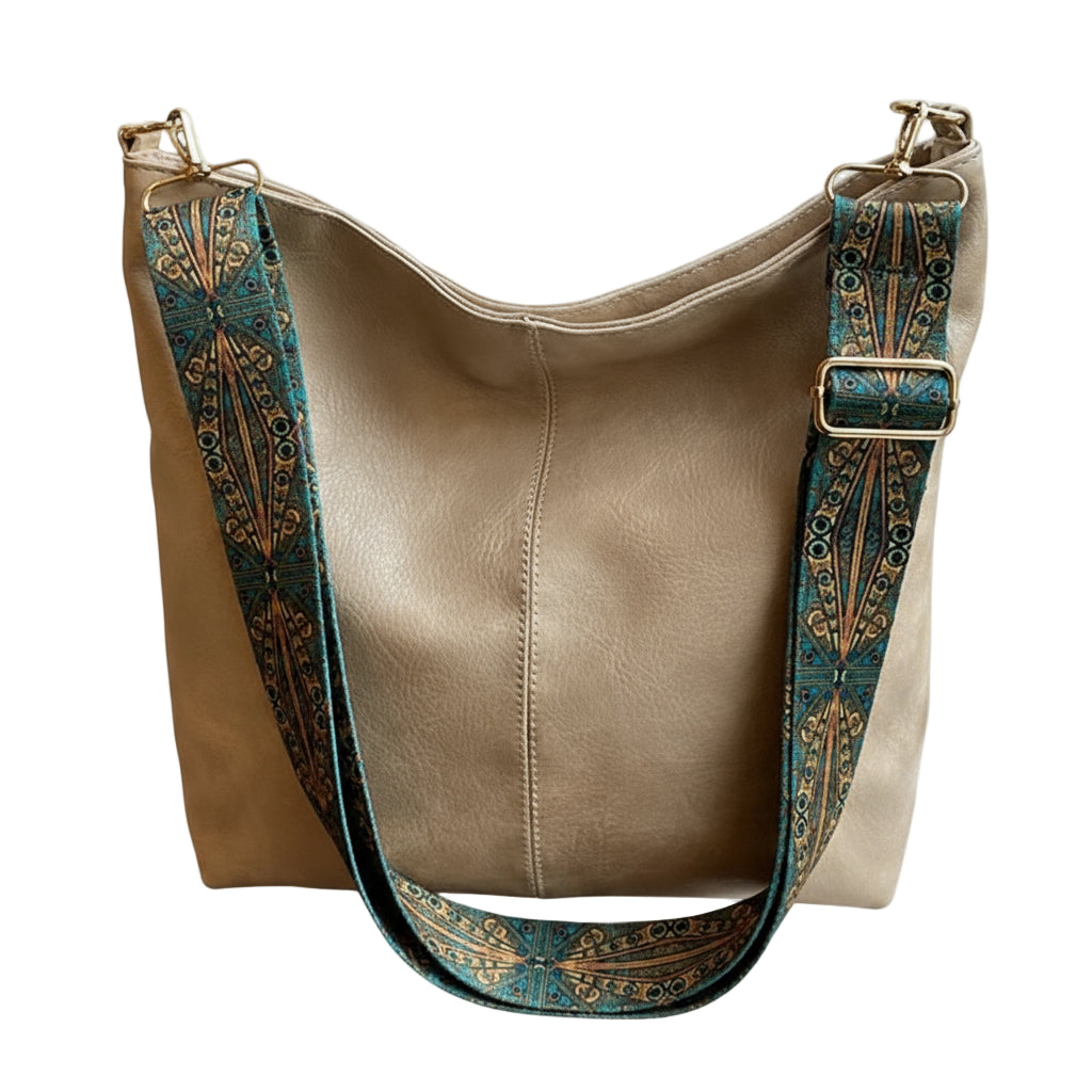 Beige handbag with decorative strap on a surface near a window